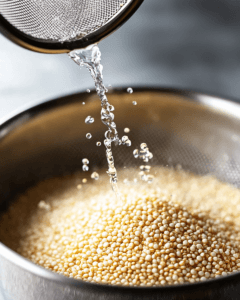 Rinsing quinoa seeds in a strainer.
