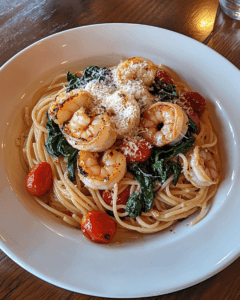 Spaghetti dish featuring shrimp, vegetables, and grated Parmesan cheese