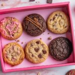 Crumbl cookies in their iconic pink box with assorted flavors